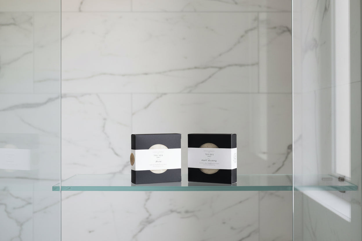 Two solid shampoo and conditioner bars in black packaging with labels.