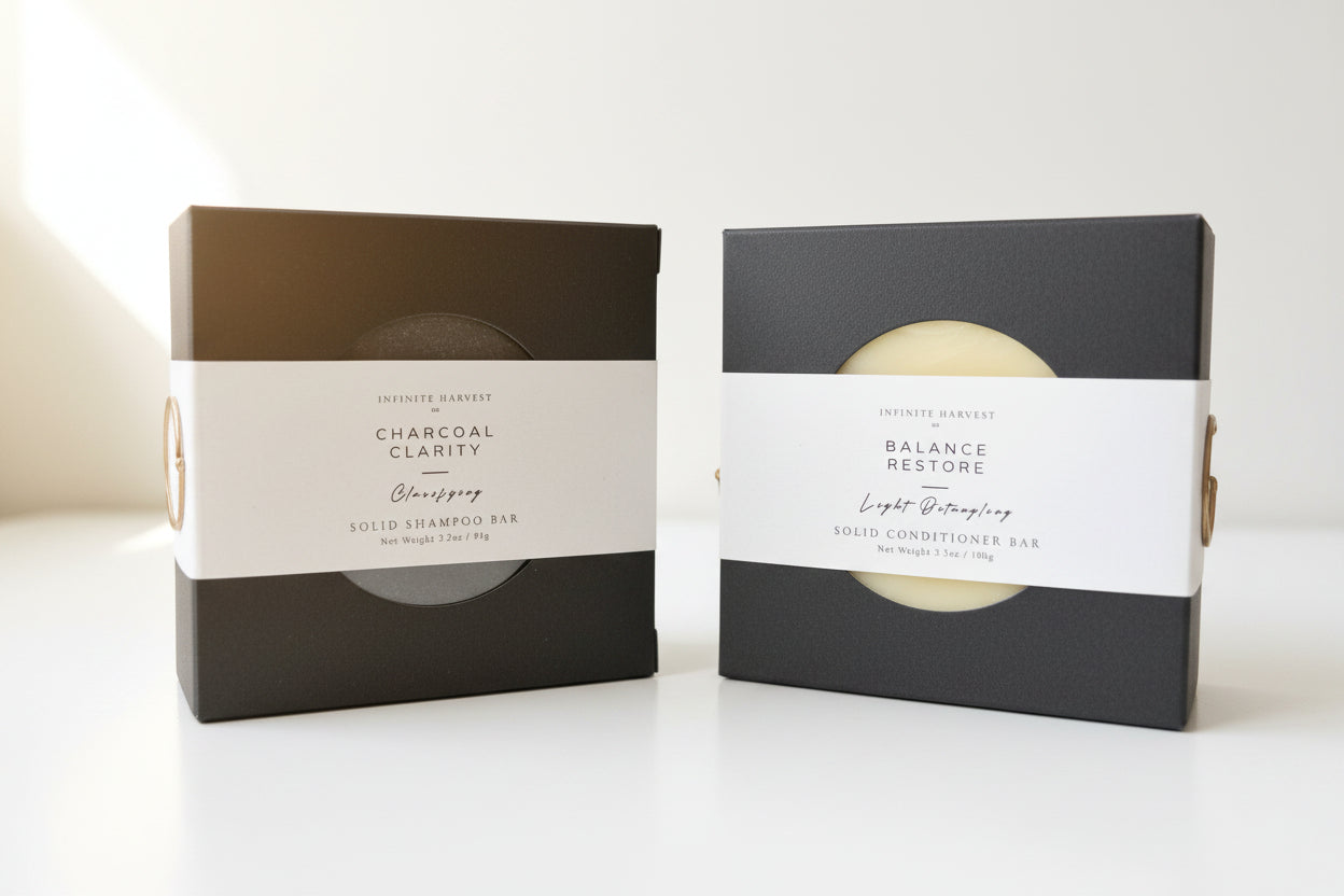 Solid shampoo bar on the left called Charcoal clarity and a solid conditioner bar on the right called Balance Restore. 